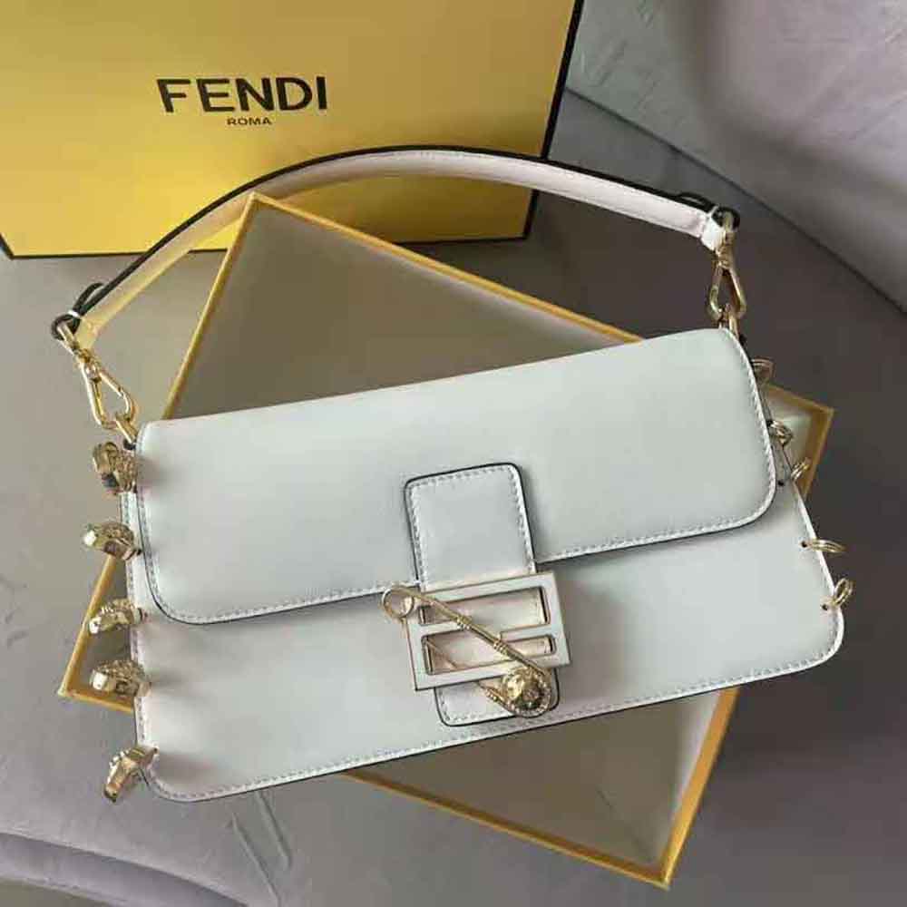 Close-up of gold-tone brooch hardware on Fendace white leather bag