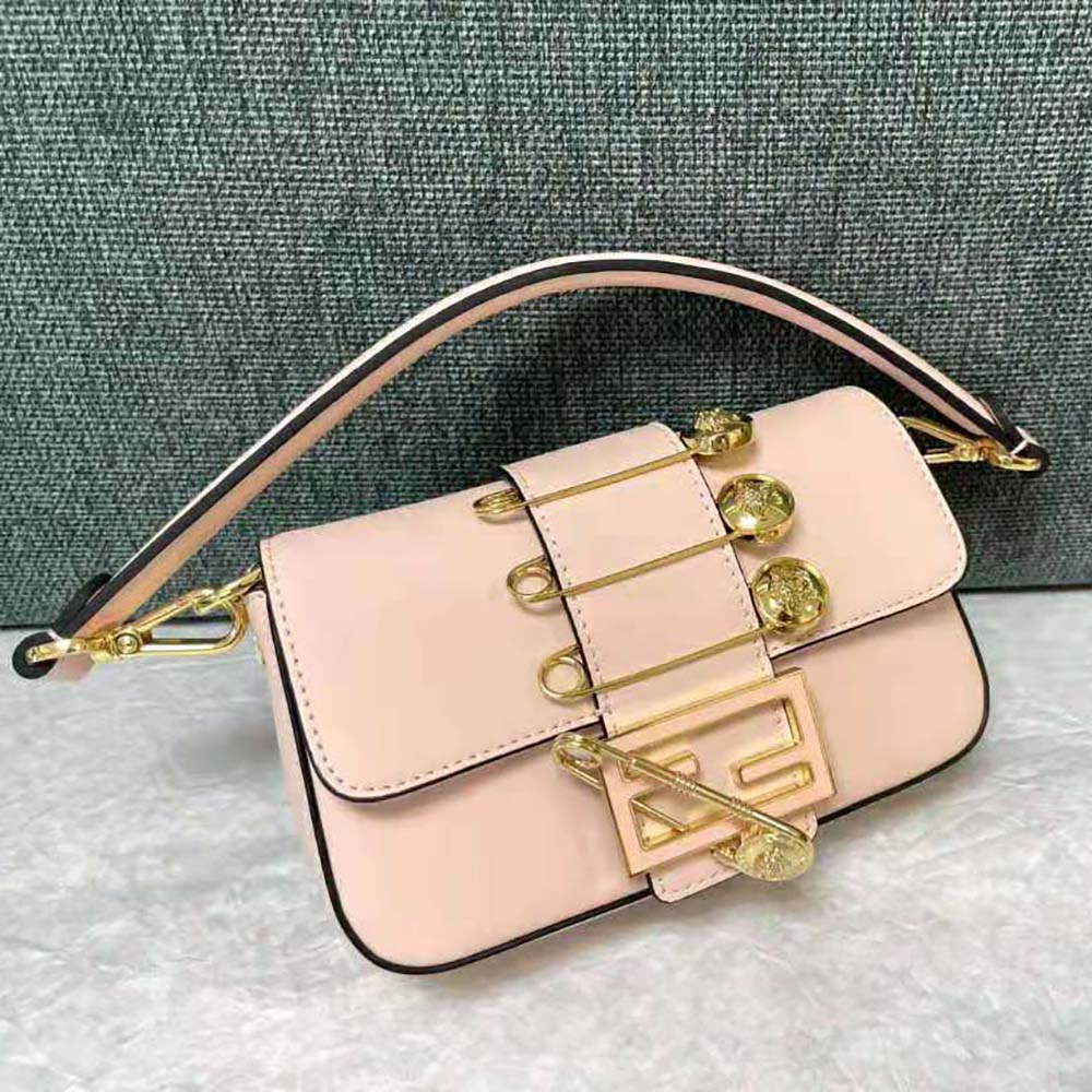 Close-up of gold-tone Fendace brooch hardware on pink leather bag
