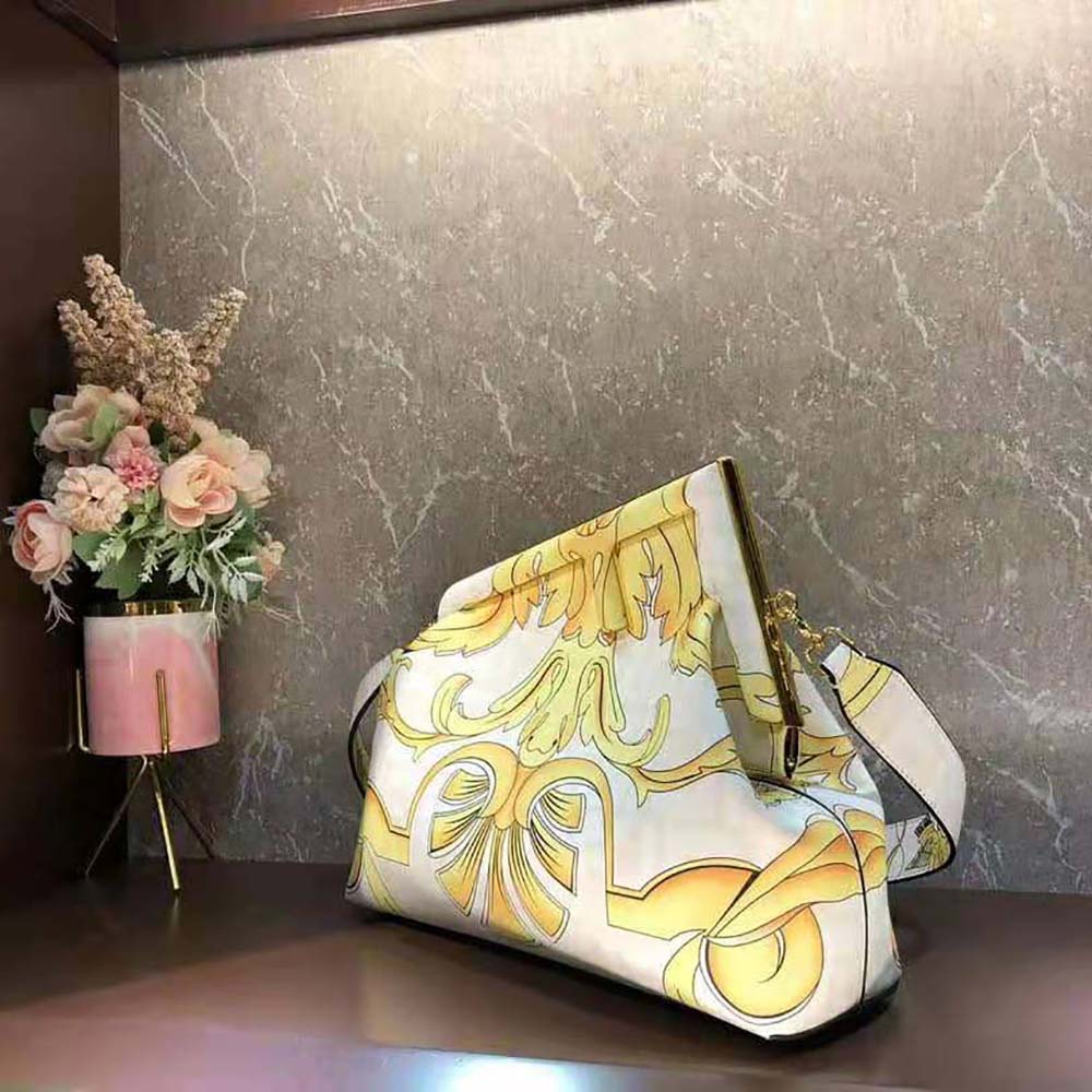Close-up of gold Fendace logo hardware on silk shoulder bag
