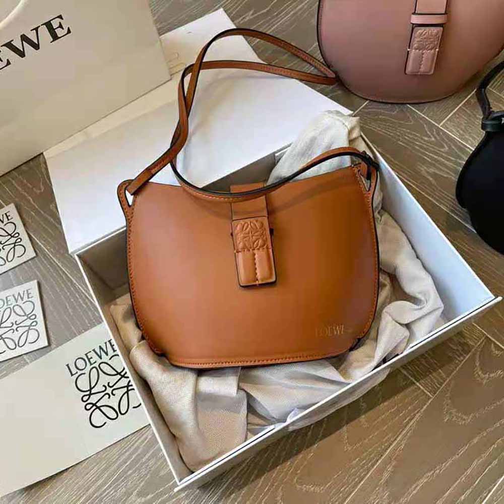 Close-up on polished hardware and brown calfskin texture of Loewe bucket bag