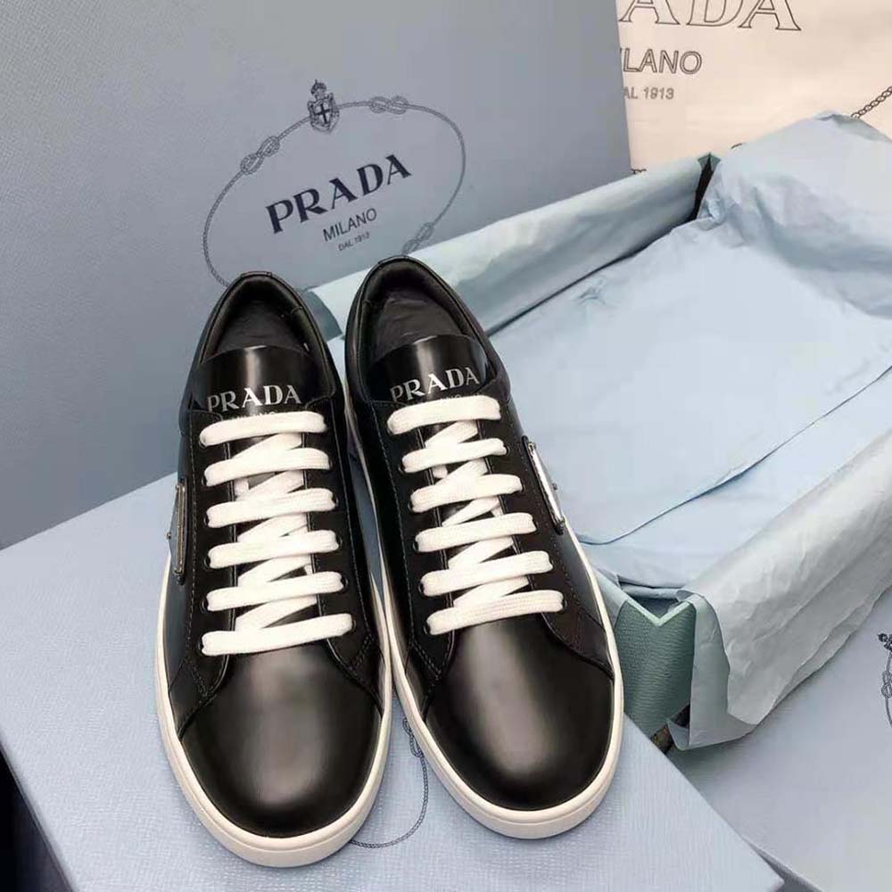 Close-up of lace-up detail and brushed black leather on Prada sneakers