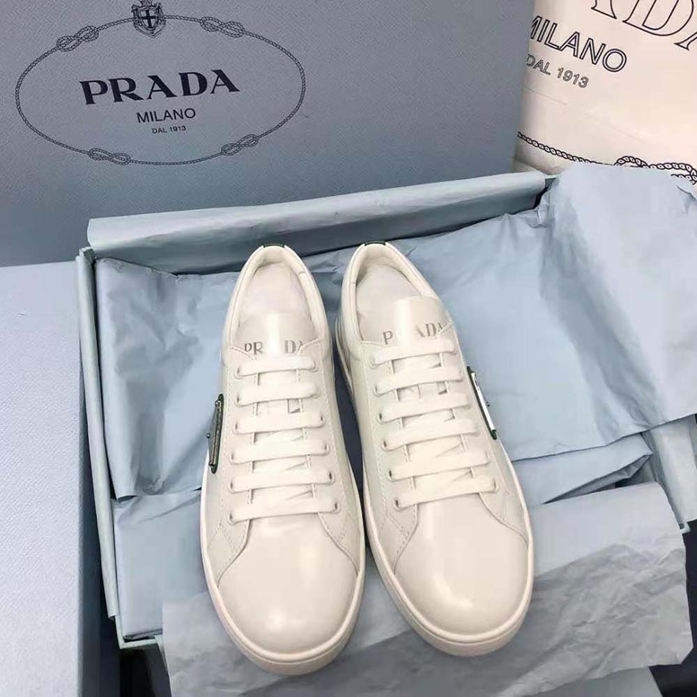 Close-up of green brushed leather and Prada logo hardware on sneakers