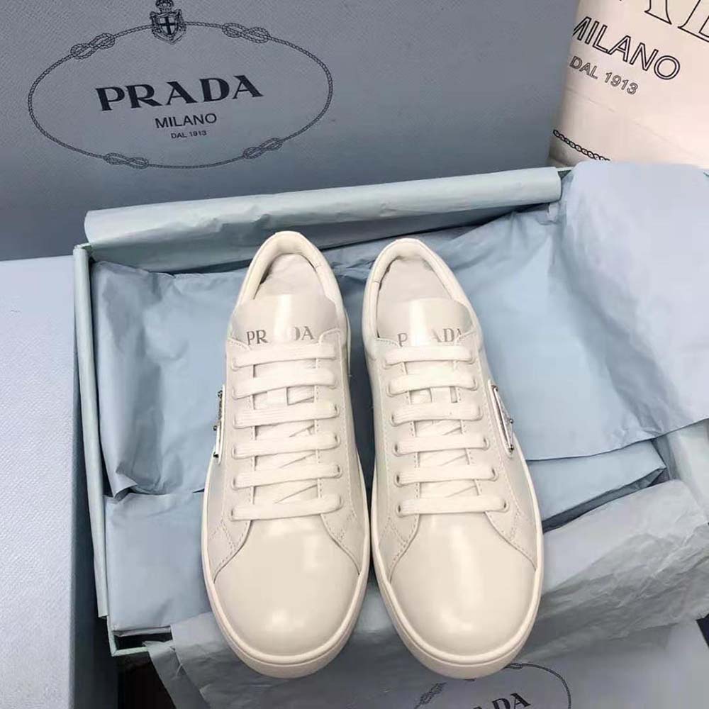 Close-up of brushed leather texture and Prada logo on white sneakers