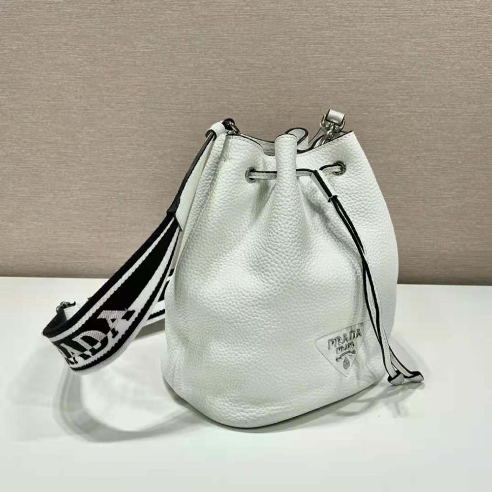 Close-up of silver-tone Prada logo hardware on white leather bag