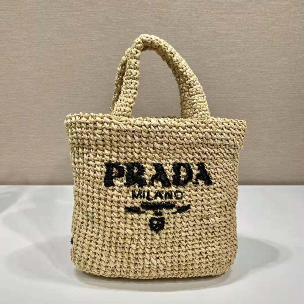 Close-up of natural raffia weave and Prada logo on tote bag