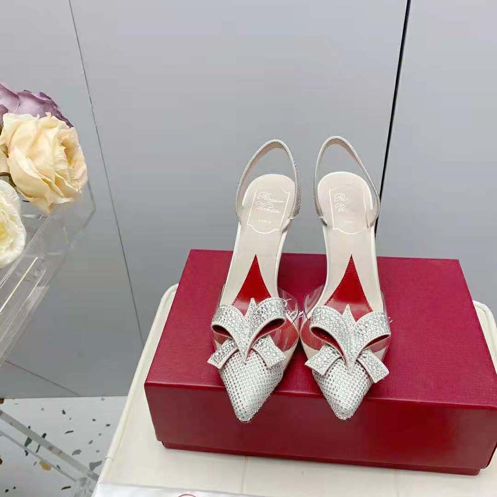 Close-up detail of crystal strass bow on Roger Vivier silver PVC pumps