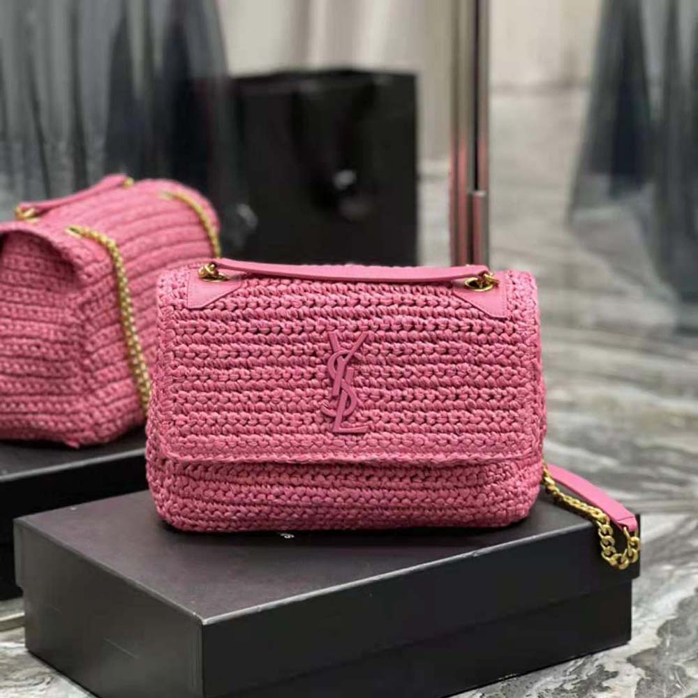 Close-up of gold chain and YSL logo on pink raffia and leather bag