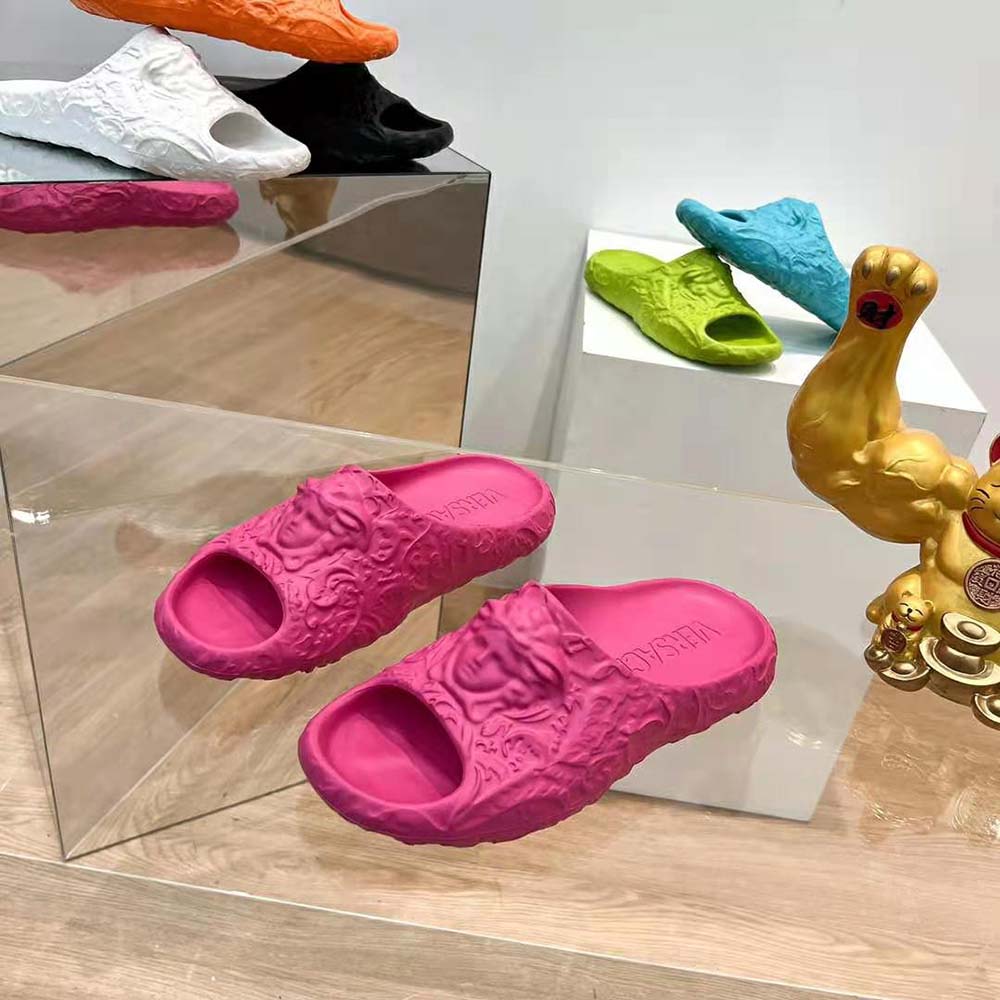Close-up on gold Medusa emblem on pink Versace Unisex Medusa Dimension Sliders