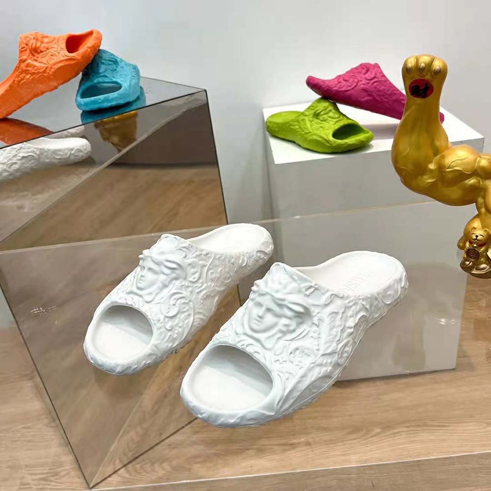 Close-up of gold Medusa emblem on white Versace Unisex Medusa Dimension Sliders