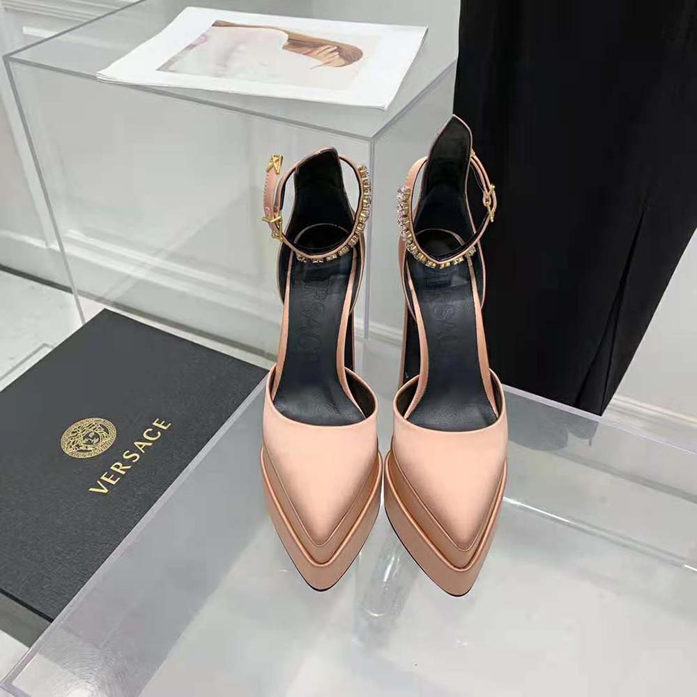 Close-up of gold Medusa emblem detail on pink Versace platform pumps