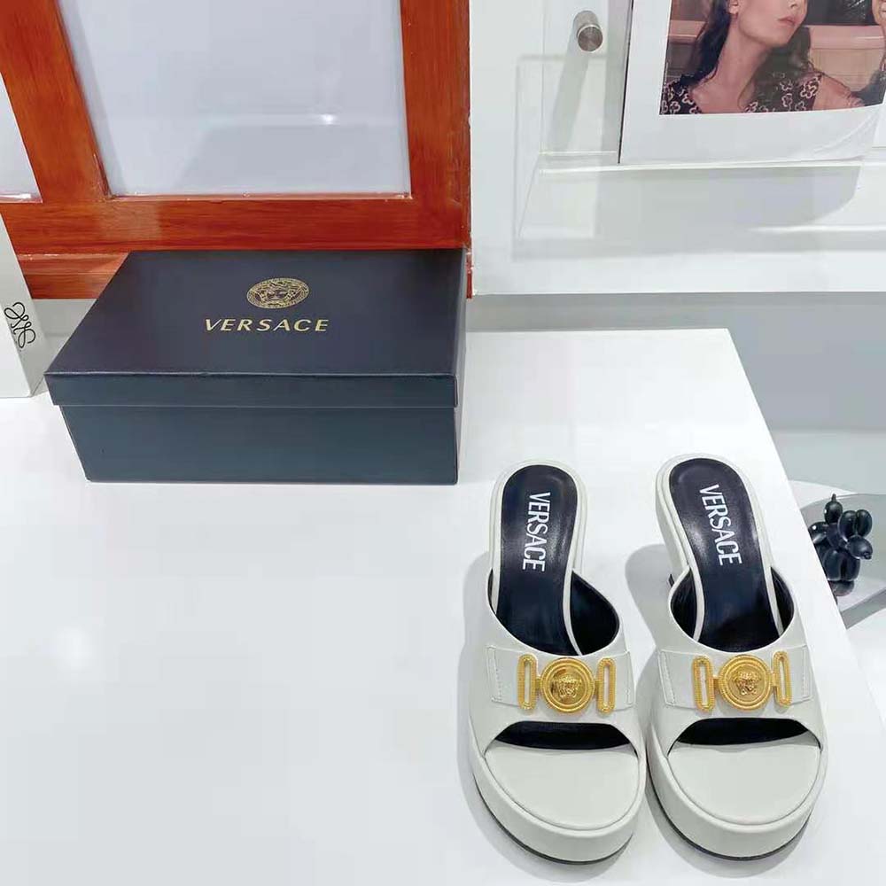 Close-up of gold Medusa emblem on Versace Women Medusa Biggie Mules-White
