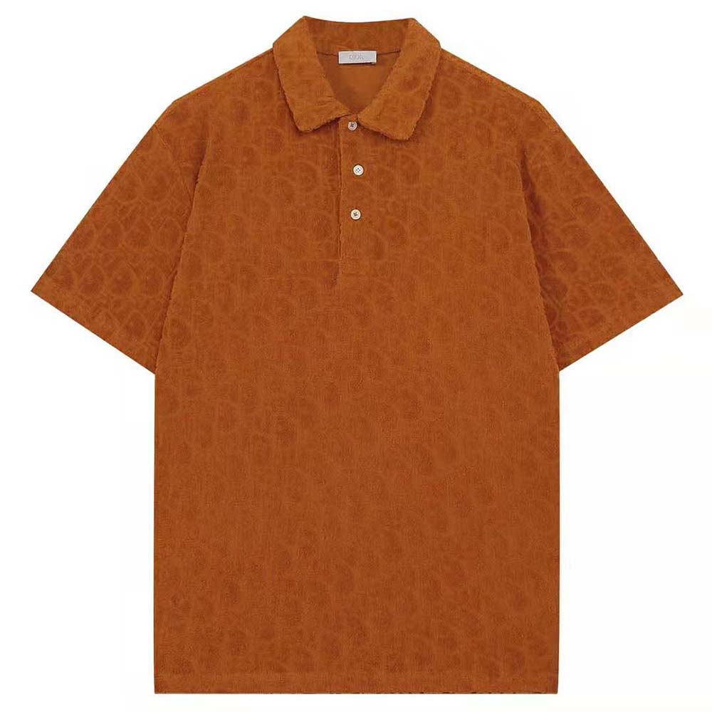 Close-up of signature Dior Oblique jacquard pattern on orange polo shirt