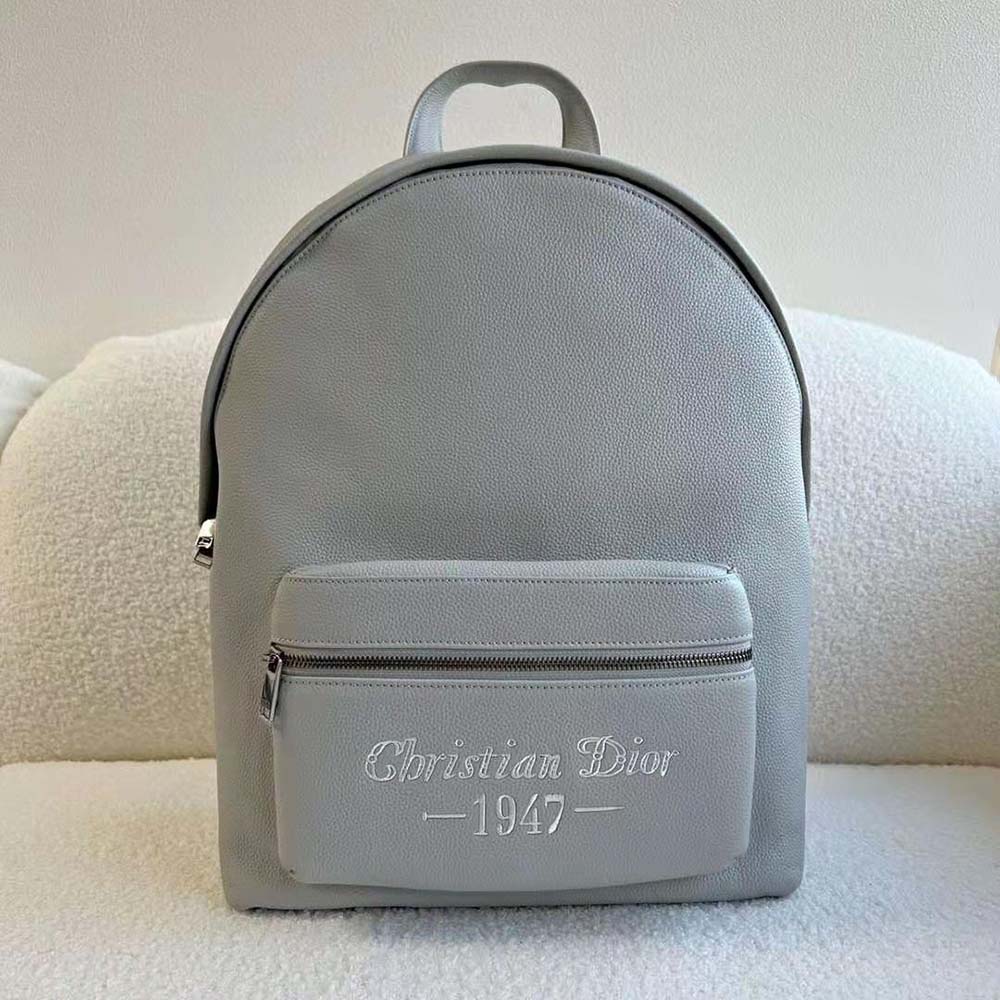 Close-up of ‘Christian Dior 1947’ signature hardware on Dior Men Rider Backpack