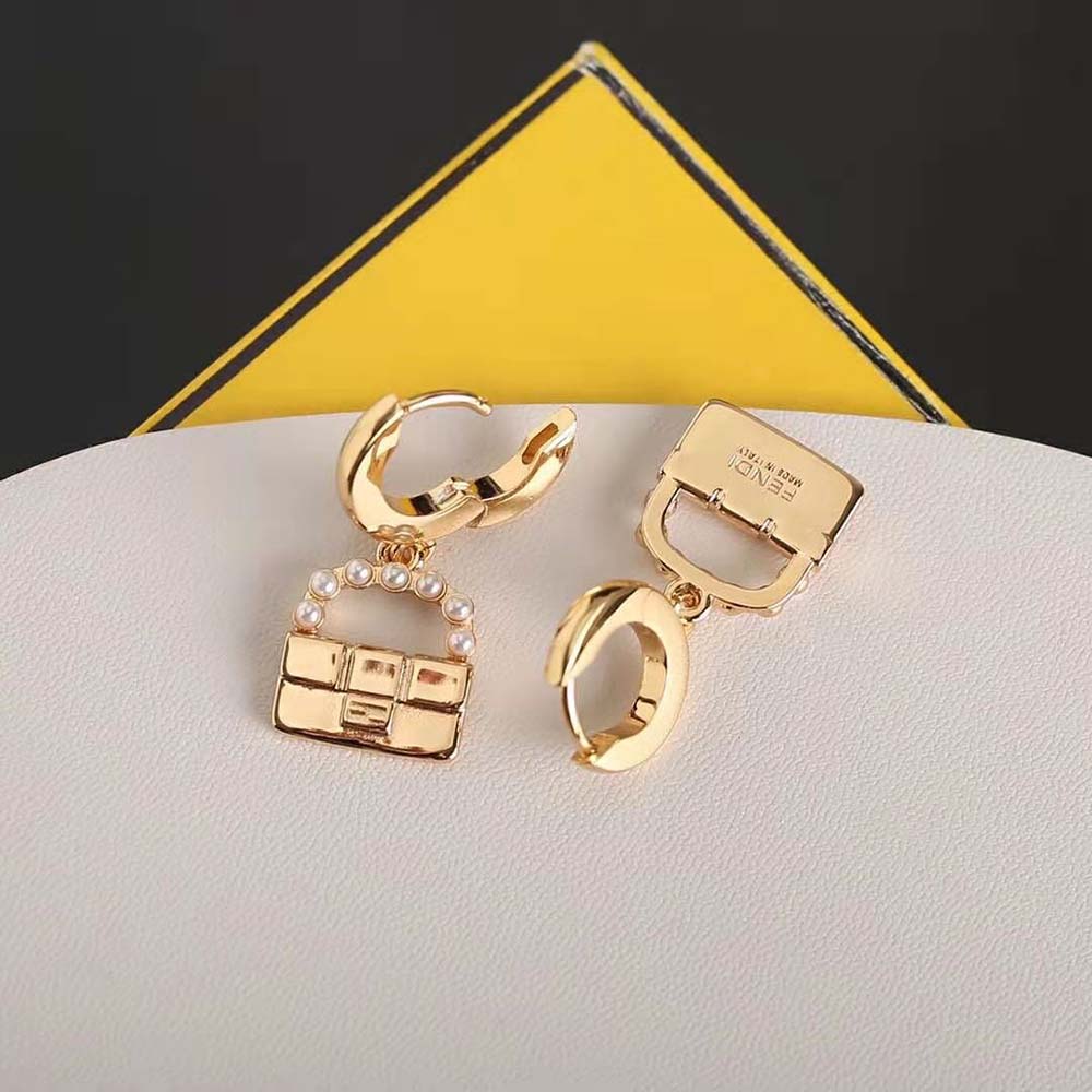 Close-up detail of Fendi logo on gold-colored baguette earrings