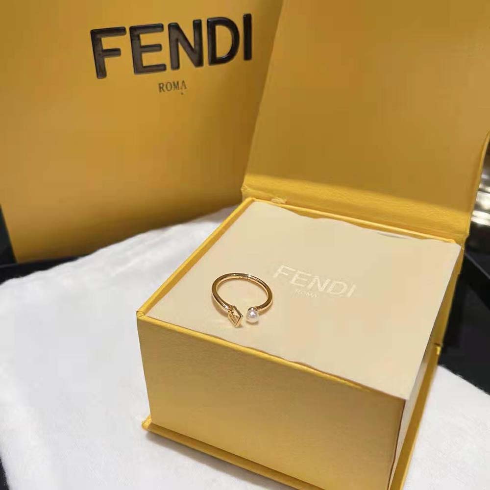 Close-up detail of Fendi logo on gold-colored baguette ring
