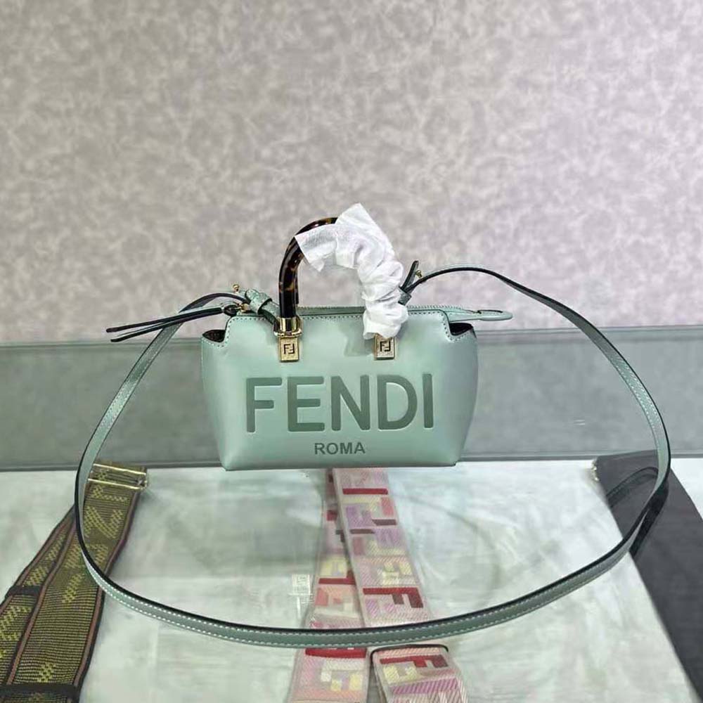 Close-up of gold-tone Fendi logo hardware on mint green leather bag
