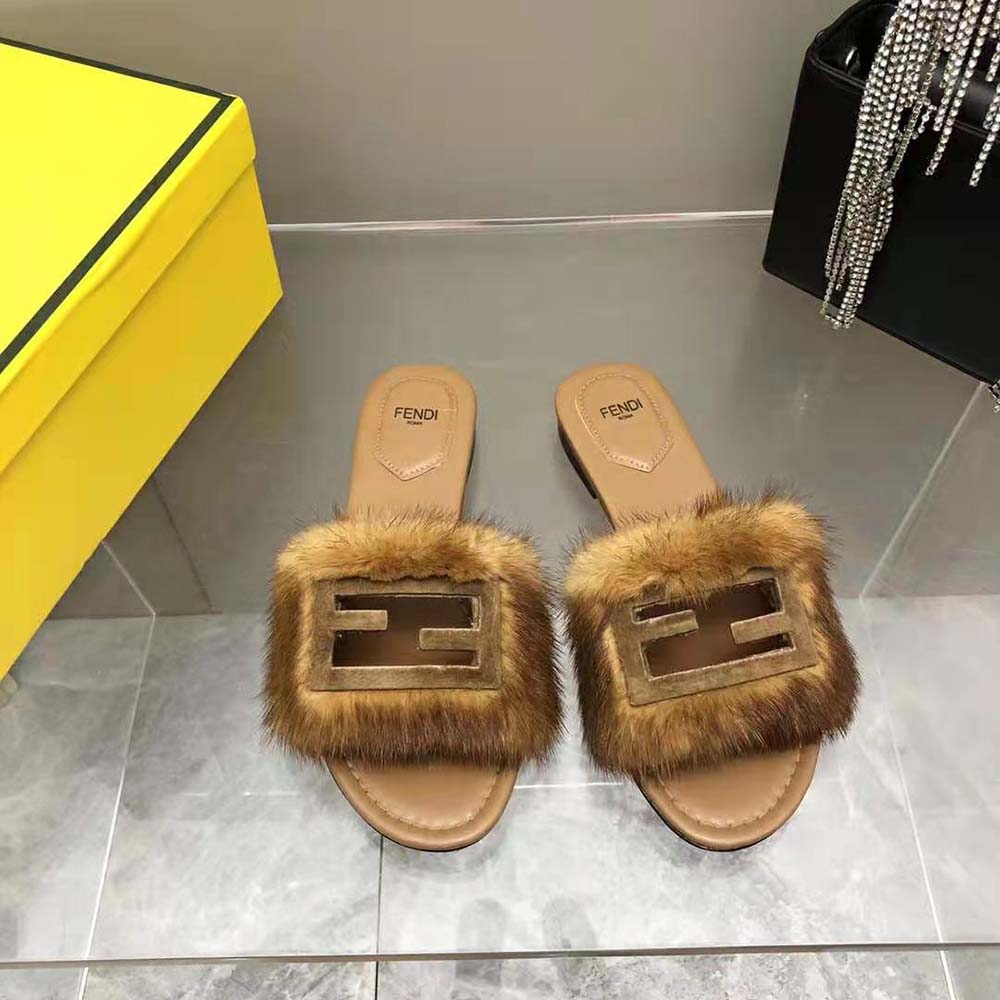 Close-up of Fendi hardware detail on brown mink slides