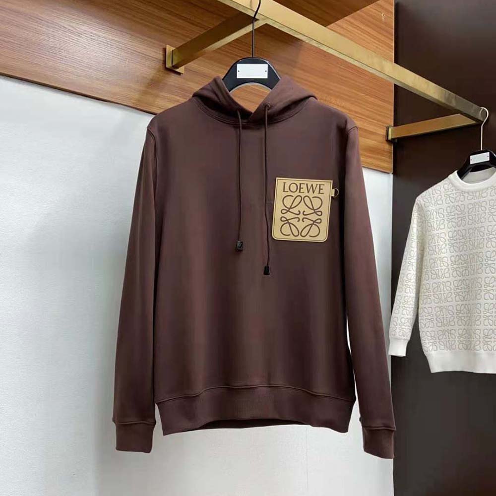 Close-up of Loewe leather Anagram patch on brown cotton hoodie
