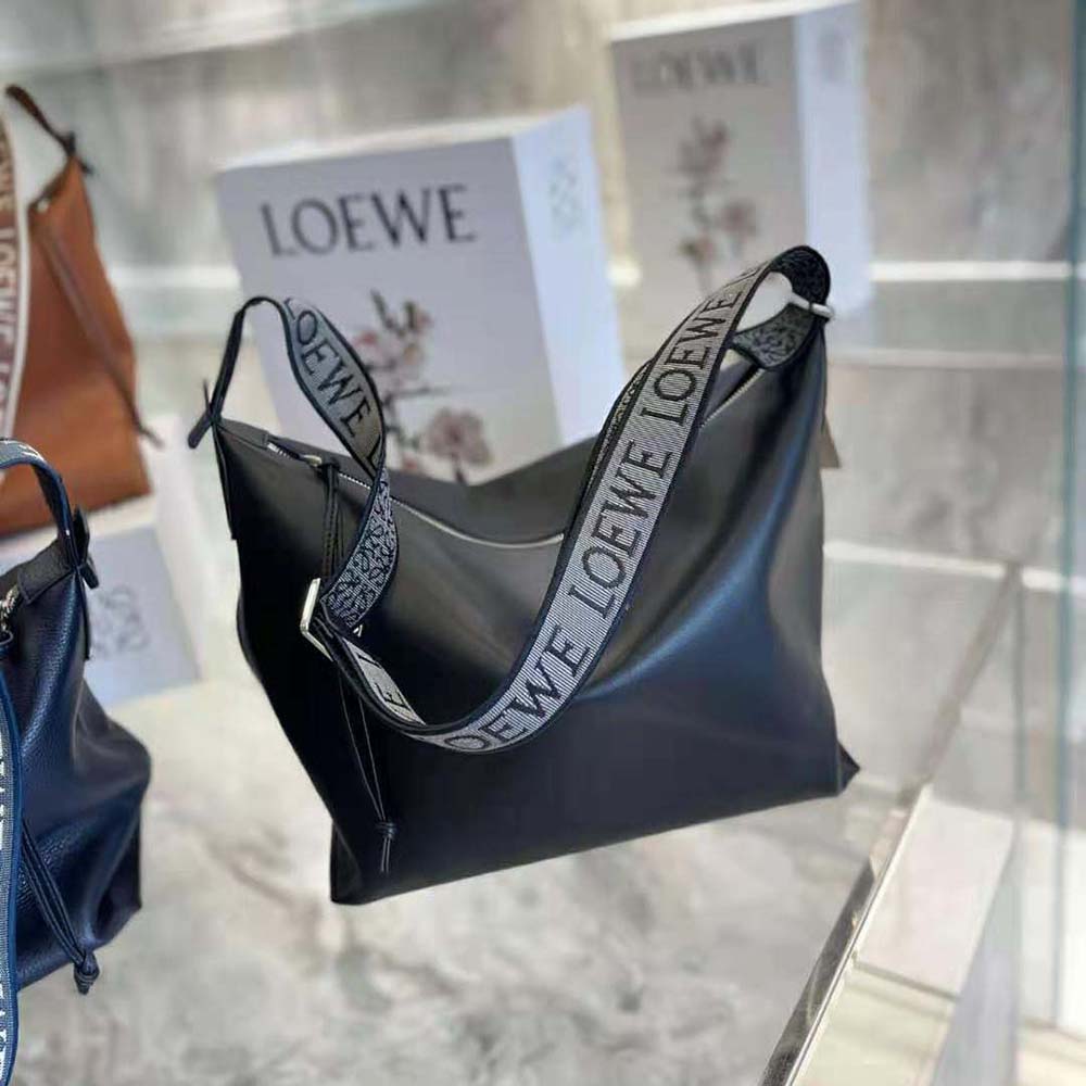 Side angle showing adjustable strap and silver hardware on Loewe Women Cubi Crossbody Bag