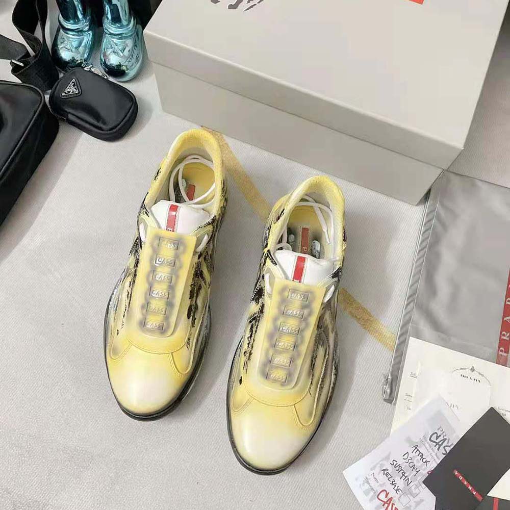 Close-up of lace-up and Prada Americas Cup logo on yellow sneakers
