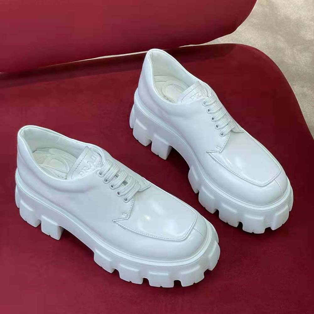 Back angle showing Prada embossed logo on heel of white shoes