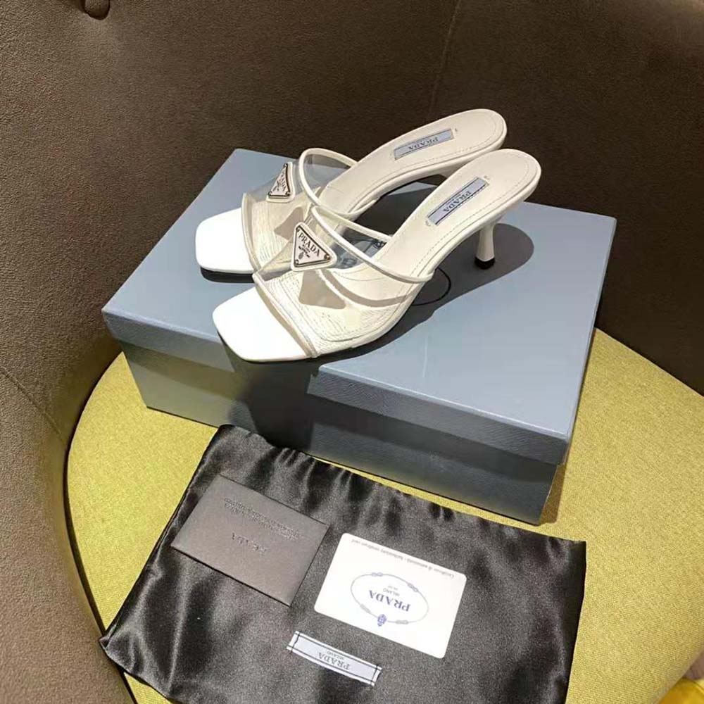 Close-up on glossy patent leather and plexiglas heel detail of Prada sandals