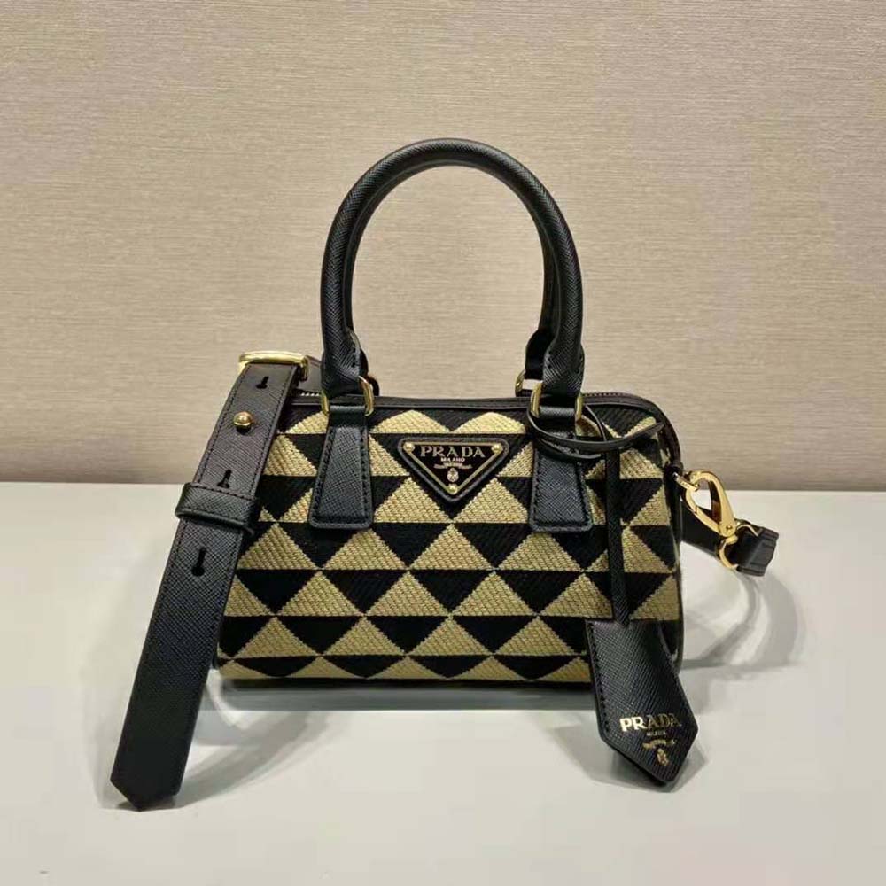 Side angle showing Prada metal logo on black top-handle bag