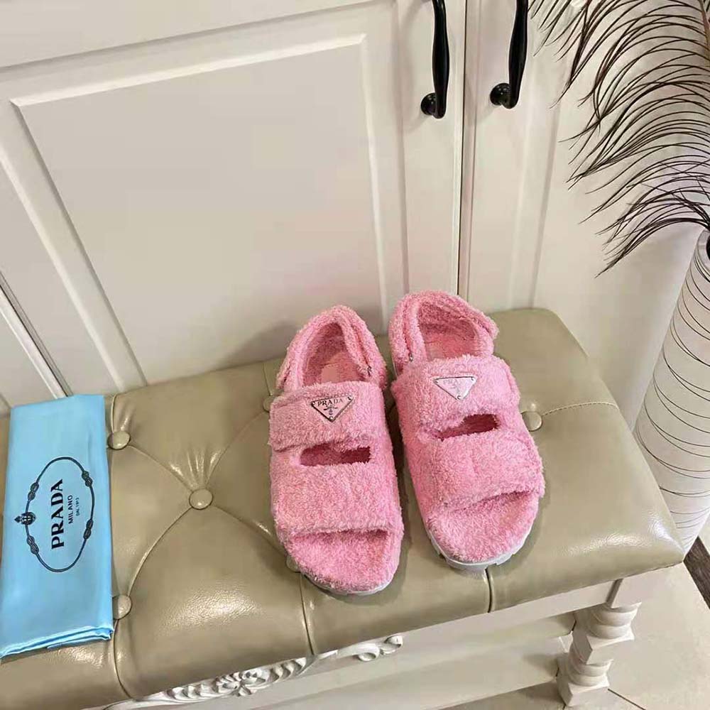 Close-up of pink terrycloth and metal triangle logo detail on Prada sandals