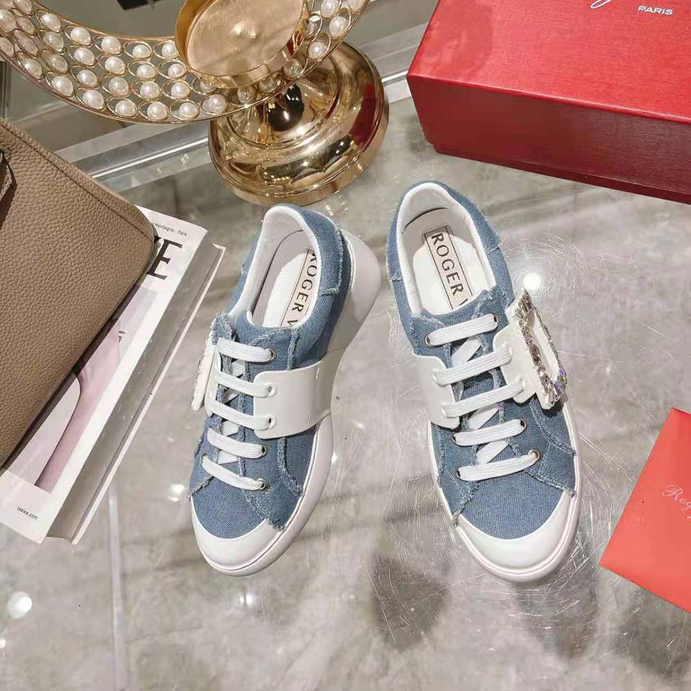 Close-up on strass buckle detail of Roger Vivier denim sneakers