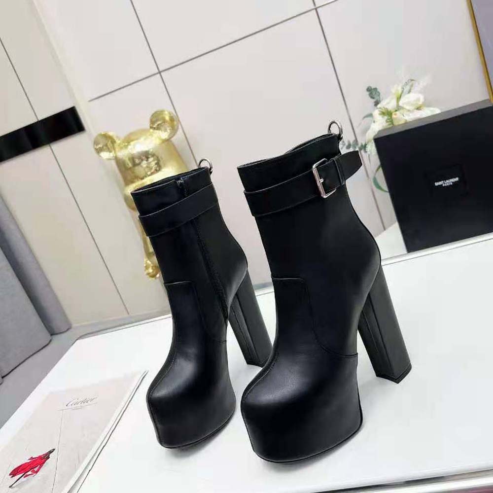 Close-up of YSL cherry buckle detail on smooth leather booties