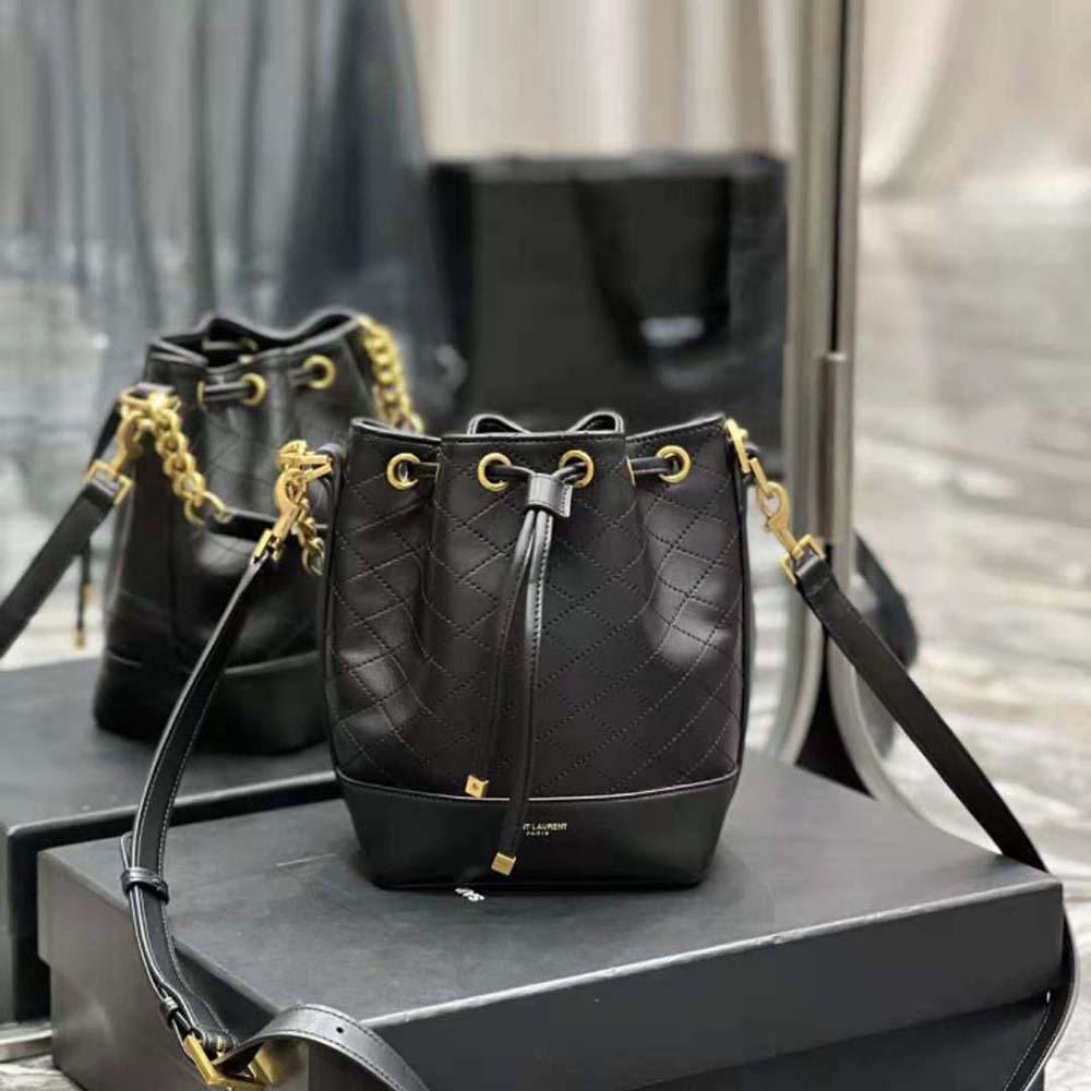 Close-up of gold YSL logo hardware on black quilted lambskin bag