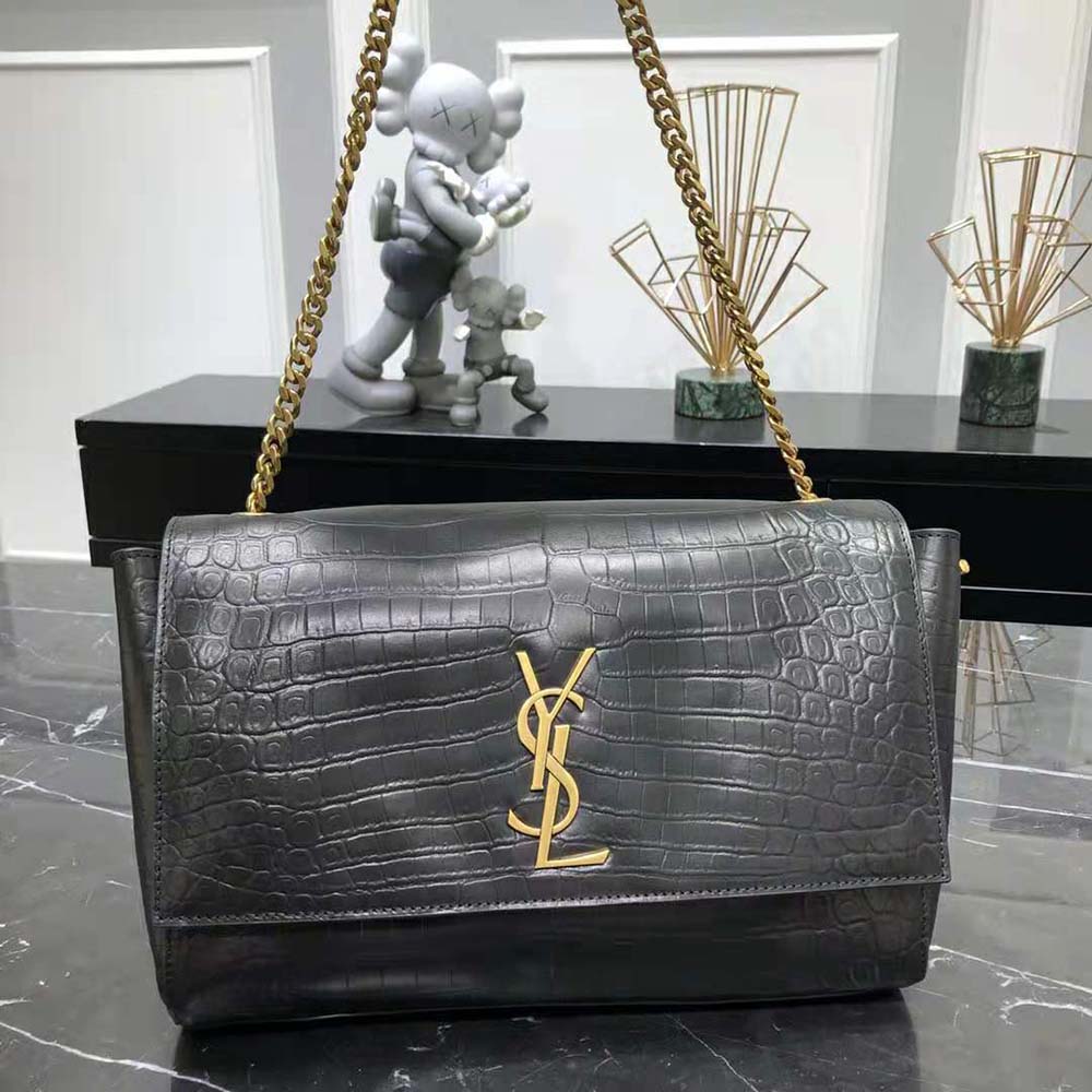 Close-up of gold YSL chain and crocodile-embossed leather detail