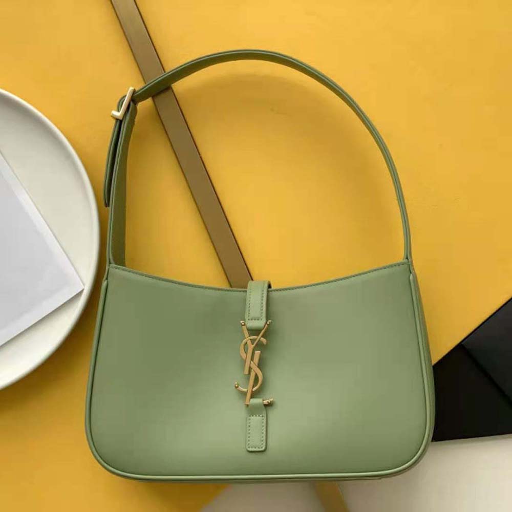 Close-up of gold YSL logo hardware on lime leather hobo bag