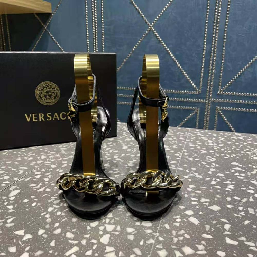 Close-up on gold Medusa chain detail of Versace sandals