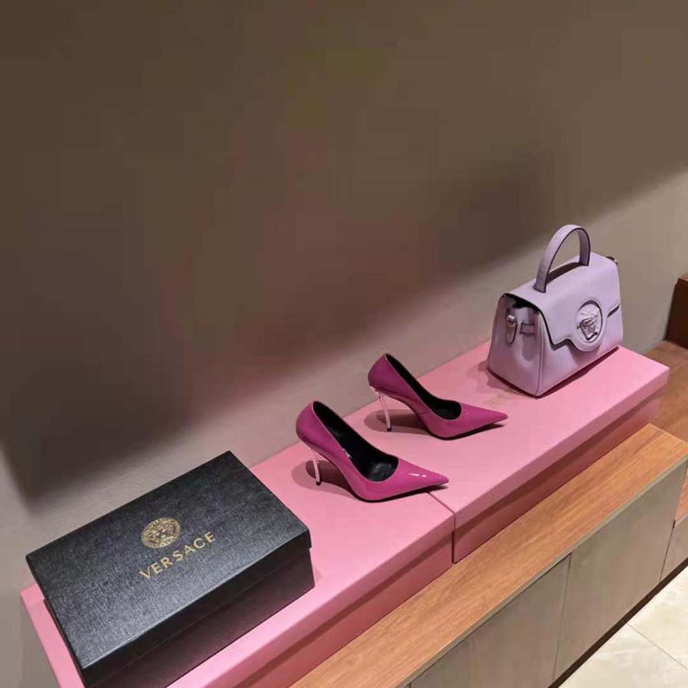Close-up of pointed toe and gold logo on Versace pink pumps