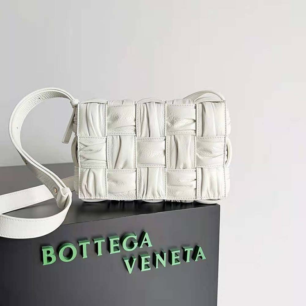 Close-up of signature intrecciato weave and gold hardware on white Bottega Veneta bag
