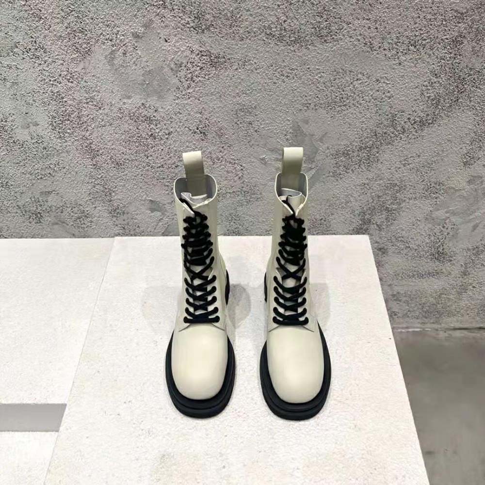 Close-up on silver-tone eyelets and white leather laces of Bottega Veneta boot
