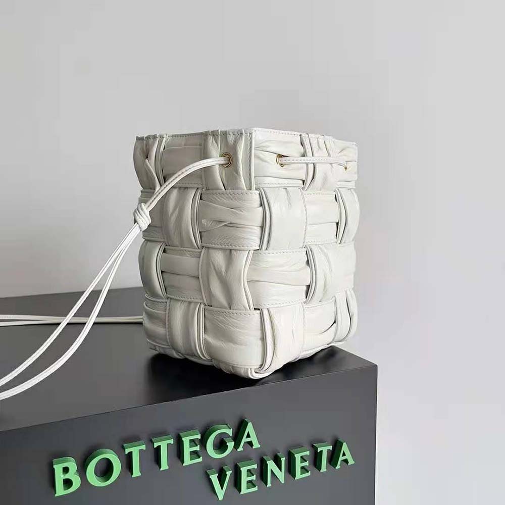 Side angle showing magnetic closure and adjustable strap on Bottega Veneta White bucket bag