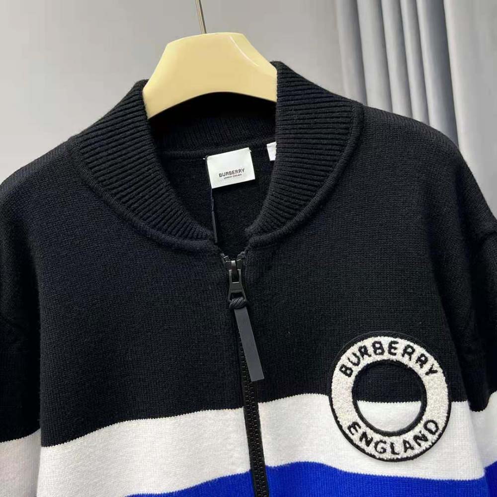 Close-up detail of Burberry logo stripe on black bomber jacket sleeve