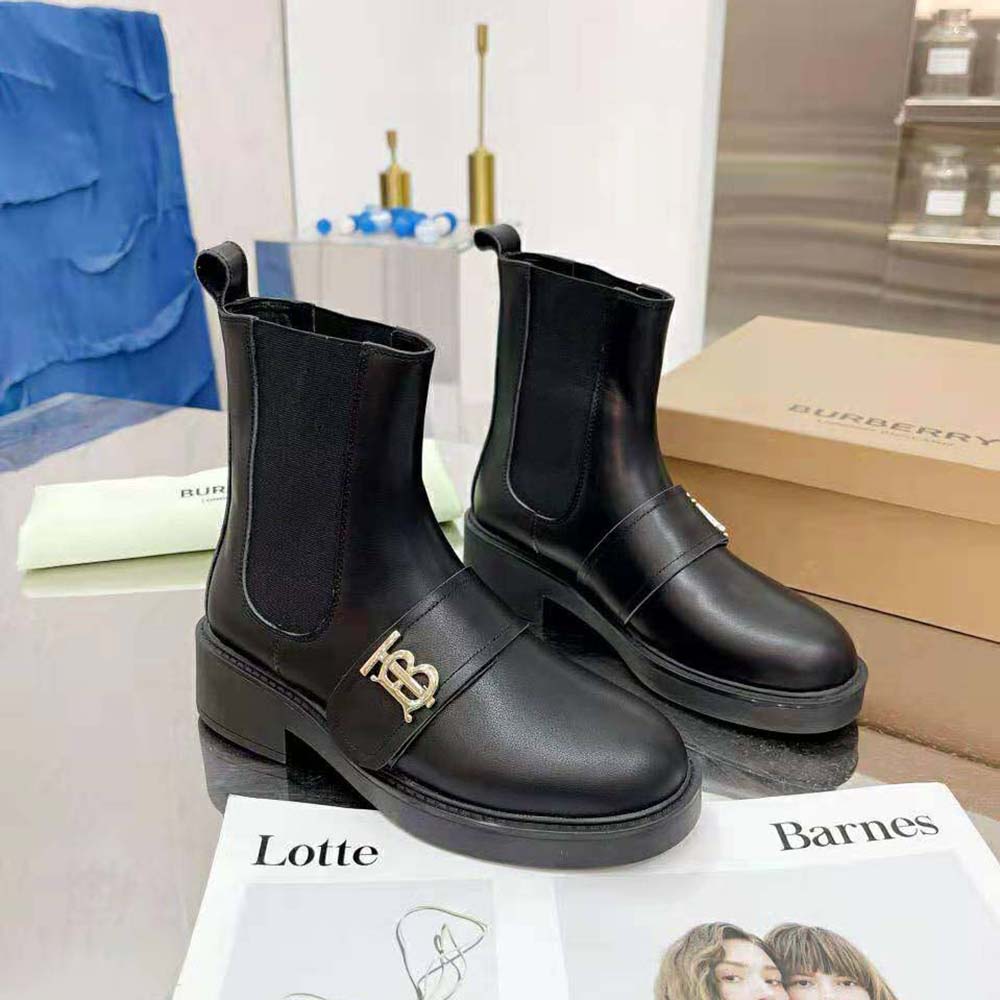 Close-up on elastic panel and monogram hardware detail of Burberry Chelsea boots