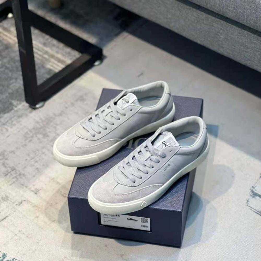 Close-up on signature Dior metallic logo on sneaker heel in gray
