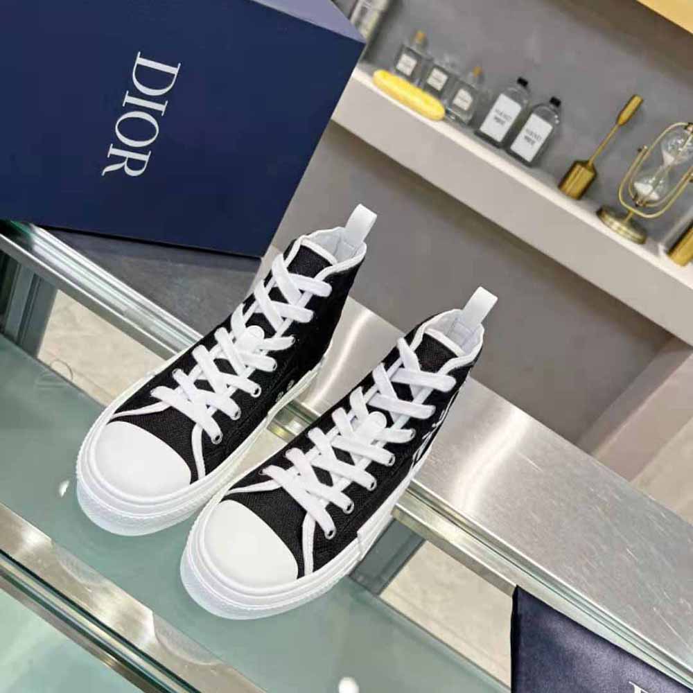 Side profile showing black and cream cotton canvas sneaker silhouette
