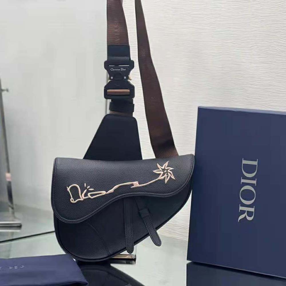 Close-up of embroidered Cactus Jack signature on Dior Men Saddle Bag