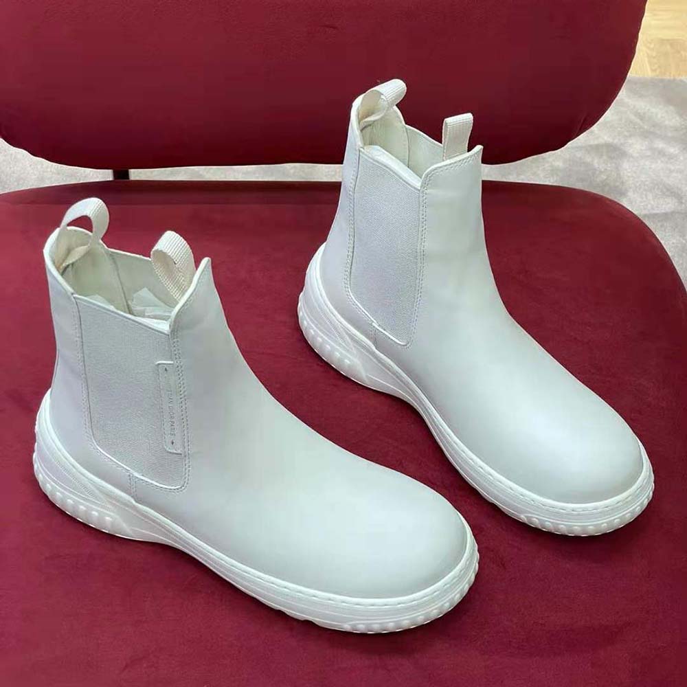 Close-up of embossed Dior hardware on white calfskin ankle boot