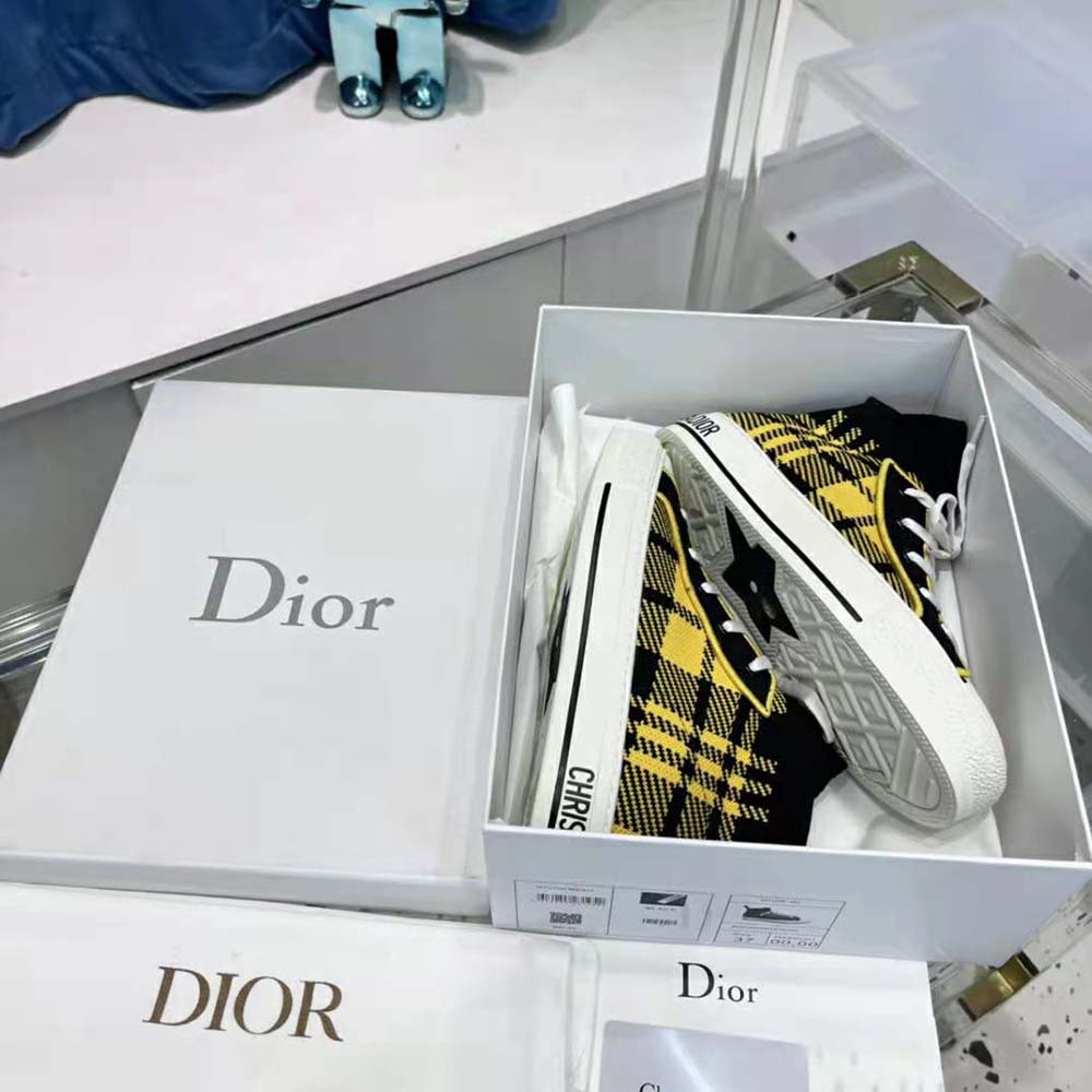 Close-up on Dior logo hardware of Yellow and Black Check’n’Dior Technical Mesh sneaker