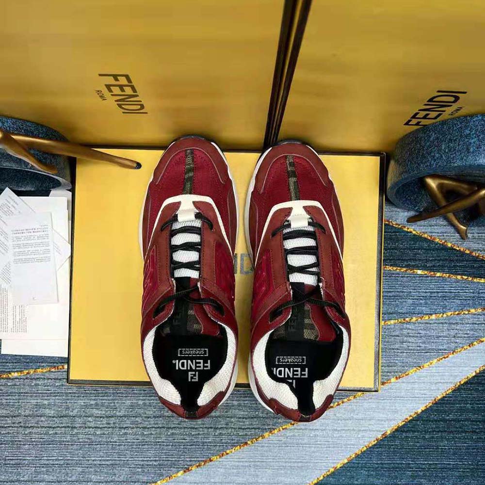 Close-up of Fendi logo hardware on burgundy nubuck leather trainers