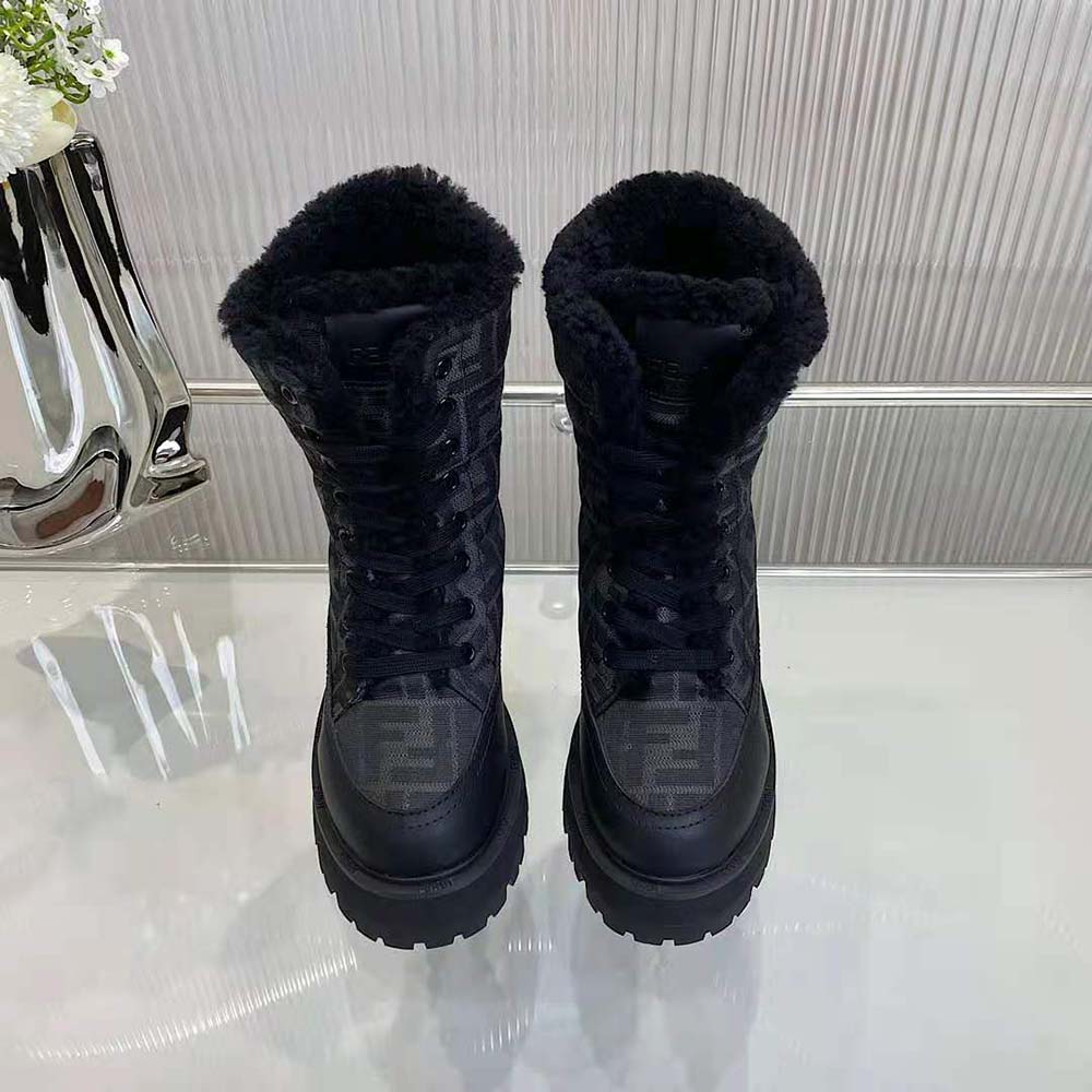 Close-up of Fendi embossed hardware on black leather biker boots