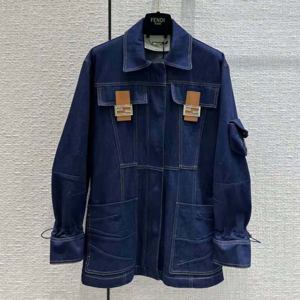 Close-up of gold-tone Fendi logo buttons on blue denim jacket