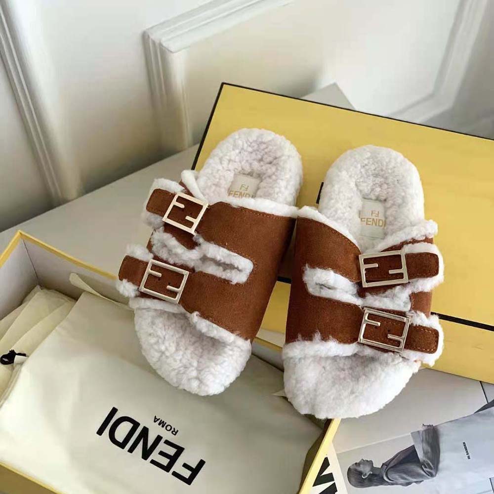 Close-up detail of gold-tone Fendi logo on sheepskin slide strap