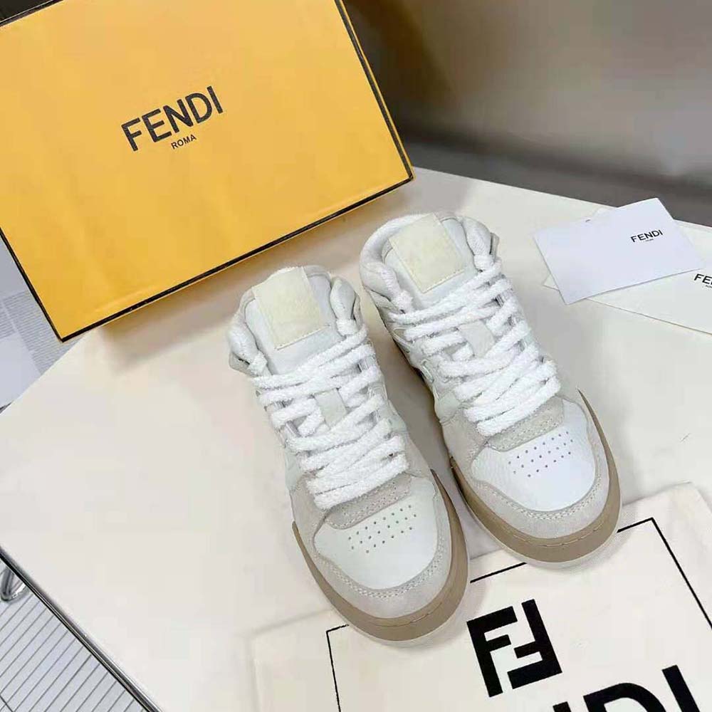 Close-up on signature Fendi logo hardware on white leather high-tops